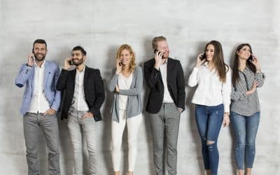 A group of business people standing in a line talking on their phones